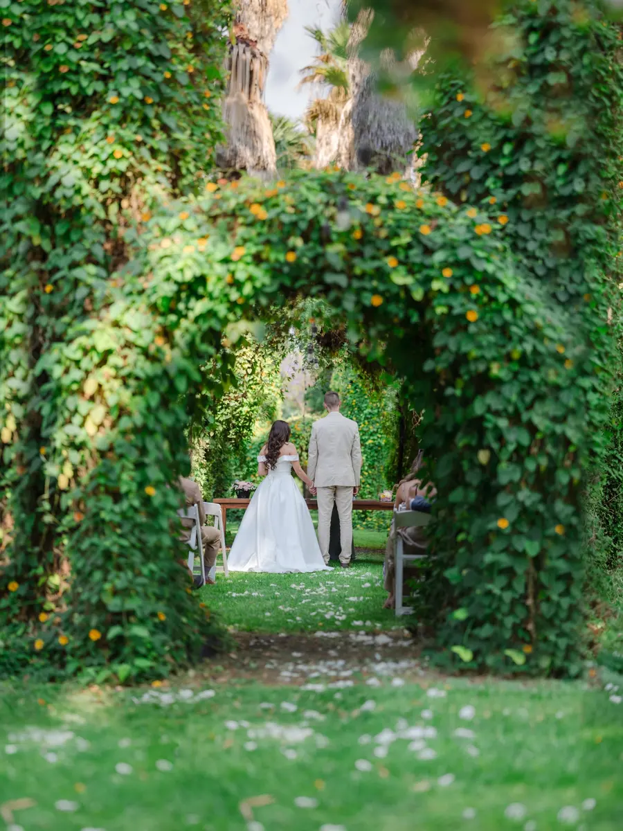 Novios bajo un arco de hojas